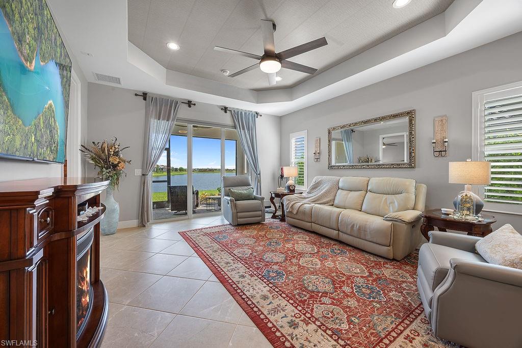 4584 Centaurus Circle Naples, FL 34120 - Photo 20 of 40 Living room with light tile patterned floors, a ceiling fan, a raised ceiling, recessed lighting, and plenty of natural light