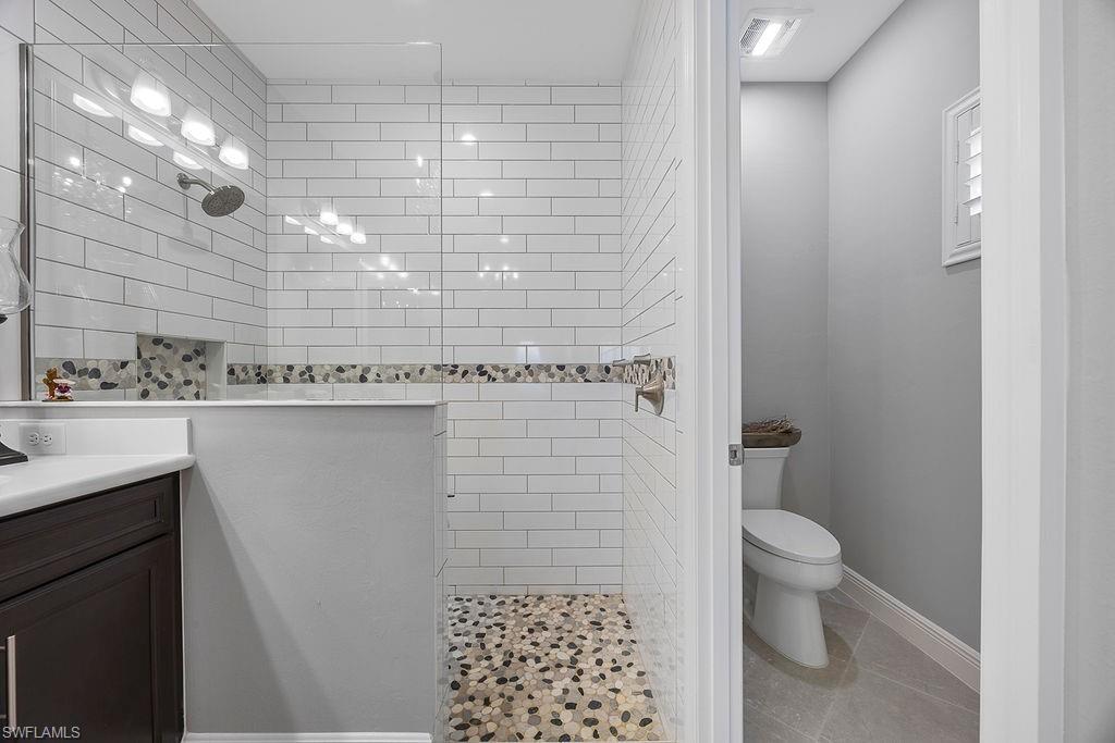 4584 Centaurus Circle Naples, FL 34120 - Photo 26 of 40 Full bathroom featuring walk in shower, vanity, and light tile patterned floors