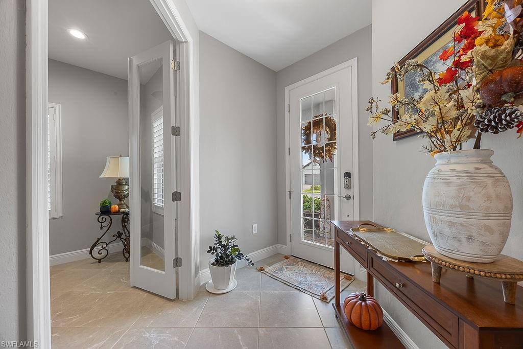 4584 Centaurus Circle Naples, FL 34120 - Photo 3 of 40 Doorway to outside featuring healthy amount of natural light and tile patterned flooring