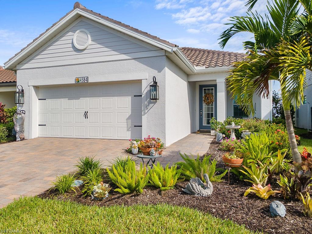 4584 Centaurus Circle Naples, FL 34120 - Photo 31 of 40 View of front facade featuring a tile roof, an attached garage, decorative driveway, and stucco siding