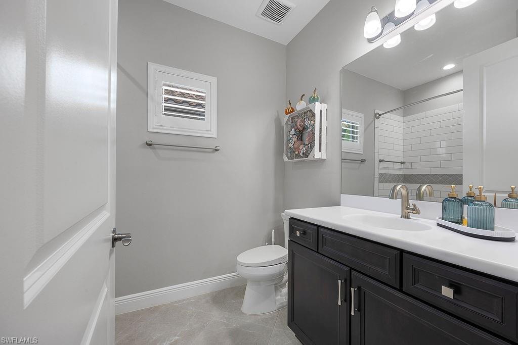 4584 Centaurus Circle Naples, FL 34120 - Photo 7 of 40 Full bathroom featuring vanity, tiled shower, and light tile patterned flooring