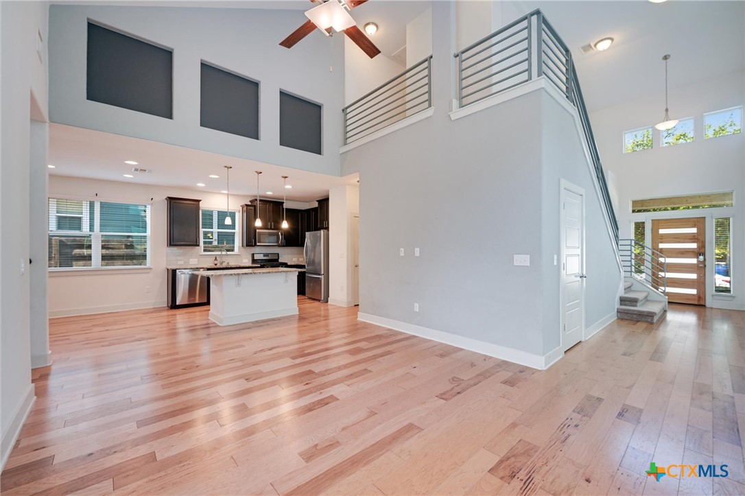 2205 Capulet Street Austin, TX 78741 - Photo 7 of 22 a view of a kitchen with kitchen island stainless steel appliances wooden floor and living room view