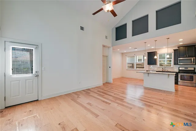 a large kitchen with stainless steel appliances kitchen island a large counter top and oven