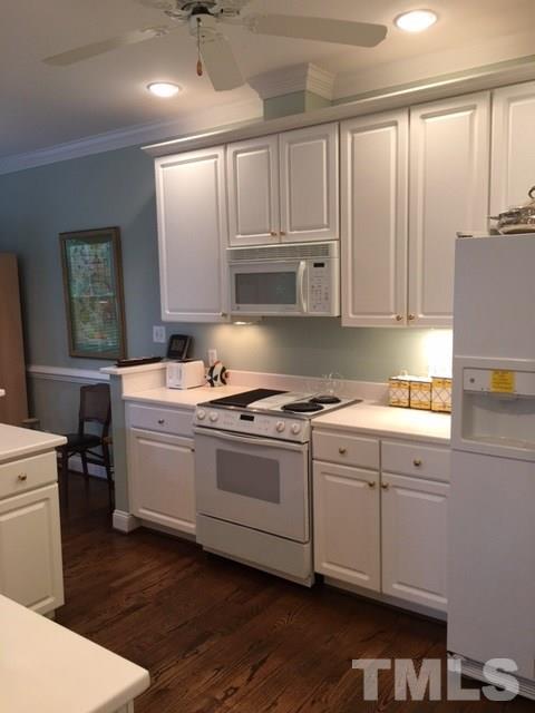 9101 Carrington Ridge Drive Raleigh, NC 27615 - Photo 7 of 14 a kitchen with kitchen island granite countertop a sink cabinets and wooden floor