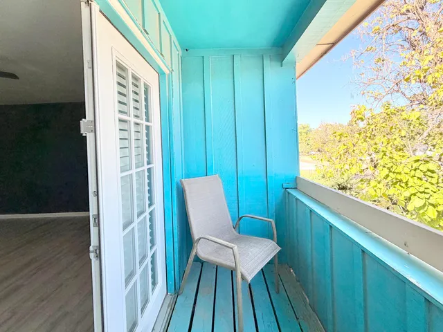 a view of a balcony with chair and wooden floor