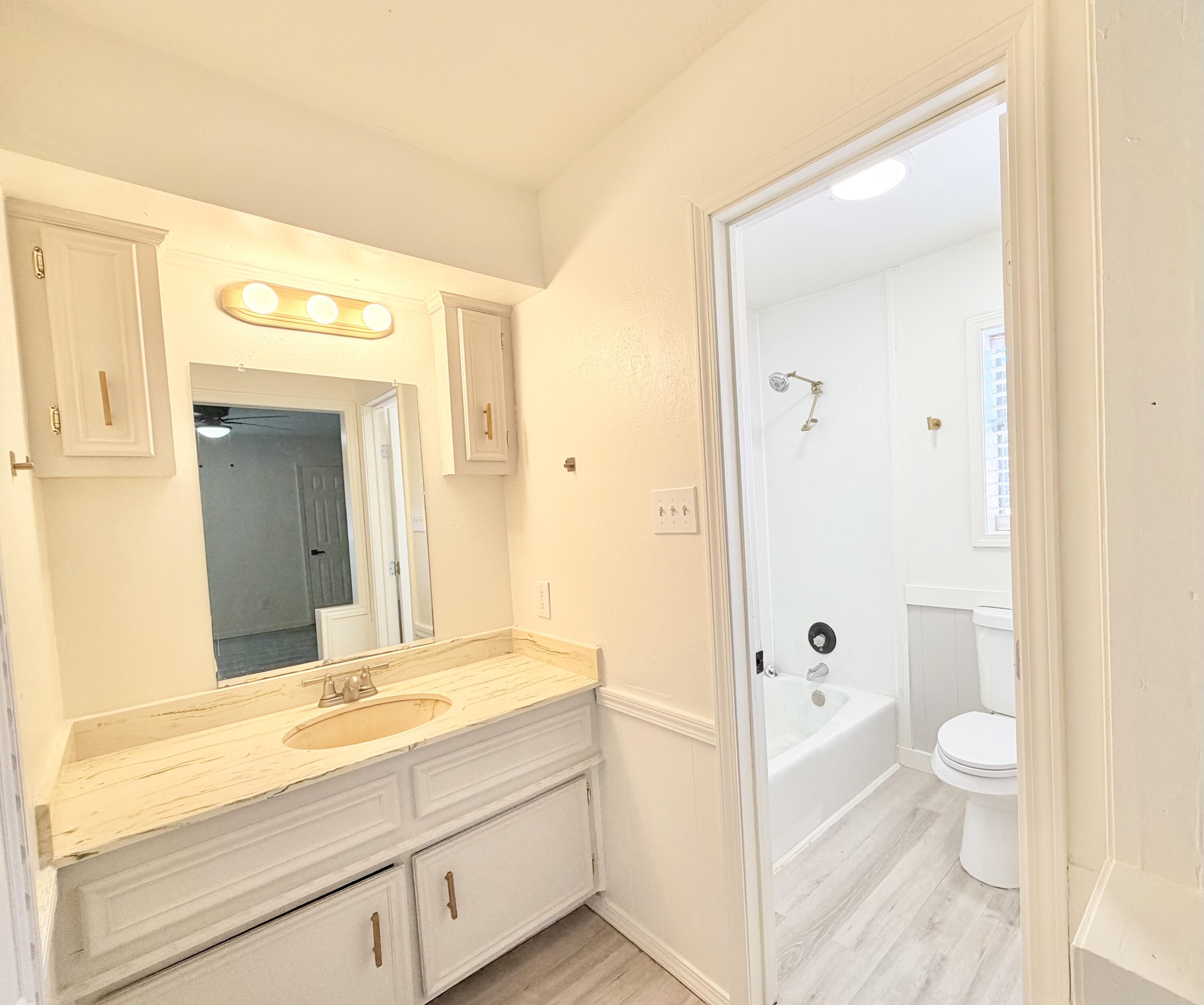 3407 30th Street Lubbock, TX 79410 - Photo 10 of 26 a bathroom with a sink a toilet and shower