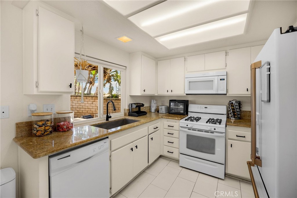 7077 Campbell Place Rancho Cucamonga, CA 91701 - Photo 17 of 74 a kitchen with white cabinets and white appliances