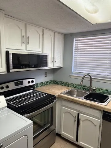 a kitchen with granite countertop a sink and cabinets