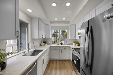 a kitchen with a sink refrigerator and cabinets