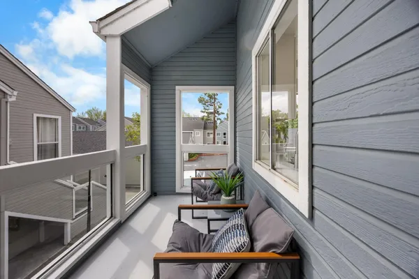 a balcony with wooden floor and furniture