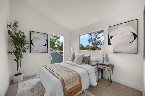 a bedroom with a bed and a painting on the wall