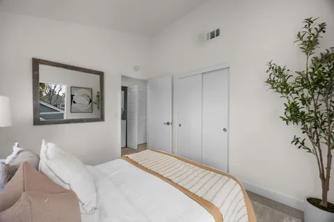 a bedroom with a bed and a potted plant