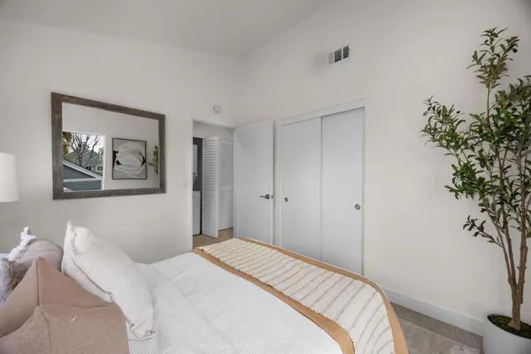 a bedroom with a bed and a potted plant