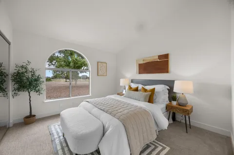 a bedroom with a bed and a large window