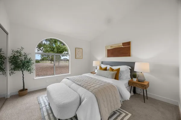 a bedroom with a bed and a large window