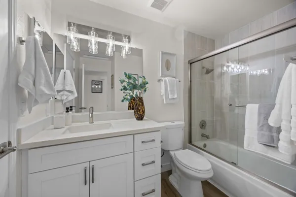 a bathroom with a sink a toilet and shower