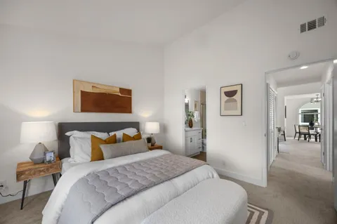 a bedroom with a bed and painting on the wall