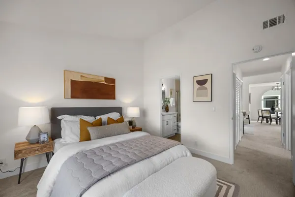 a bedroom with a bed and painting on the wall