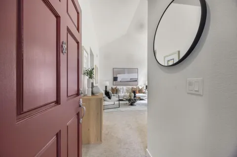 an entryway with a flower pot and a wooden floor
