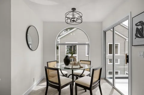 a dining room with furniture a chandelier and a window