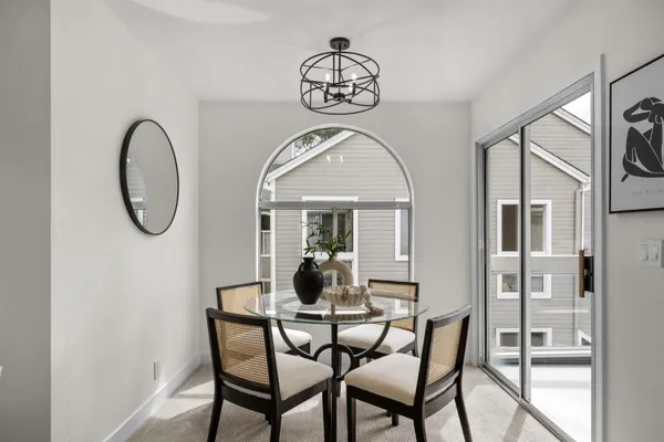 a dining room with furniture a chandelier and a window