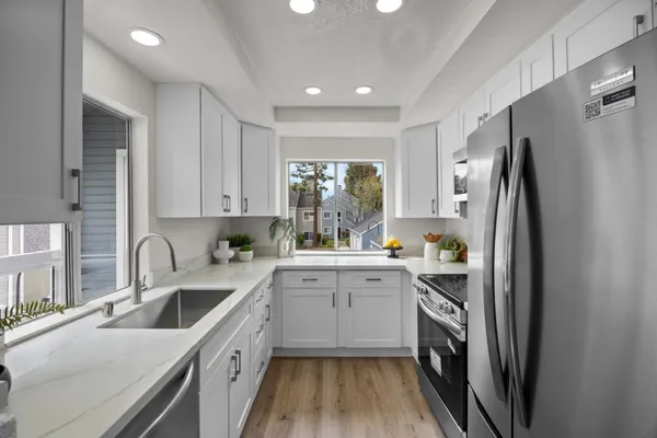 a kitchen with a sink a refrigerator and cabinets