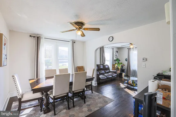 a living room with table chairs and a dining table