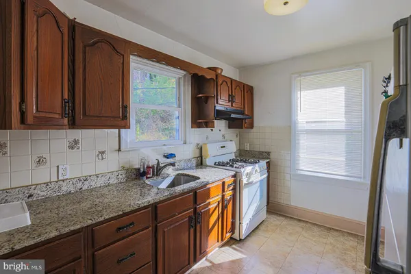 a kitchen that has a sink a stove and a microwave