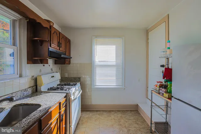 a kitchen with stainless steel appliances granite countertop a sink stove and cabinets