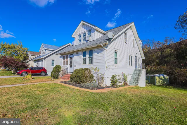 a view of a house with a yard and street