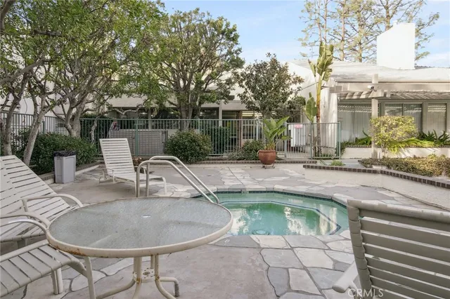 a swimming pool with outdoor seating and plants