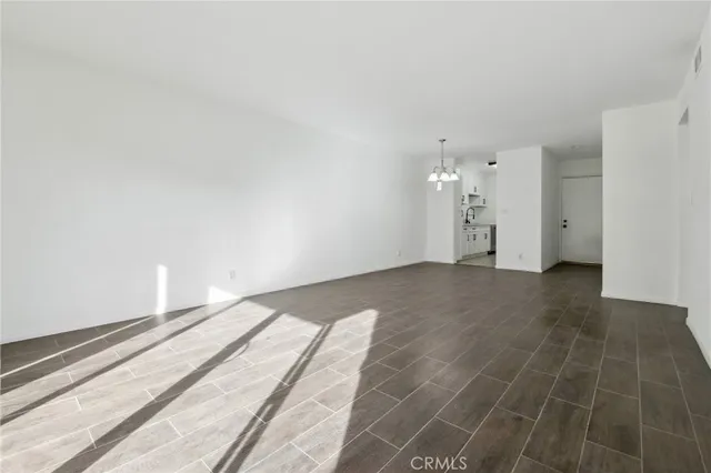 a view of an empty room with a chandelier fan