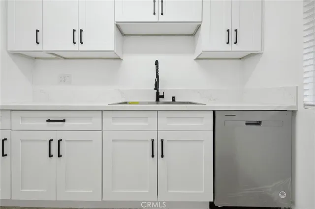 a kitchen with white cabinets and stainless steel appliances