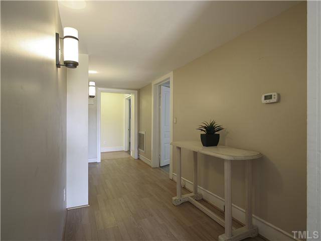 12700 School House Road Middlesex, NC 27557 - Photo 15 of 25 Central hall leads from living room to kitchen with bedrooms and hall bath access in between. Bronze light fixtures.