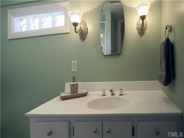 12700 School House Road Middlesex, NC 27557 - Photo 21 of 25 Both of the bathrooms have glass-block privacy windows. Soothing paint colors. Hall bath (shown here) has cultured marble vanity and decorative lighting.