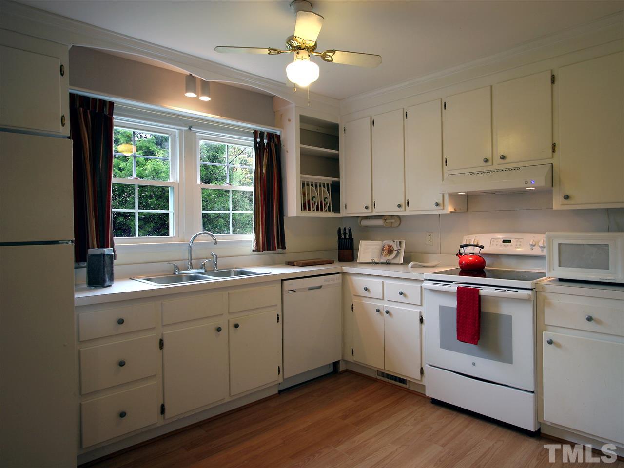 12700 School House Road Middlesex, NC 27557 - Photo 7 of 25 Large country kitchen features a stainless steel sink and white cabinets. New dishwasher and new electric range with hood. Ceiling fan with light. Windows and directional lighting over the sink.