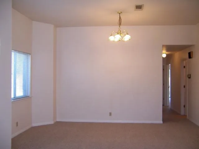 an empty room with chandelier fan