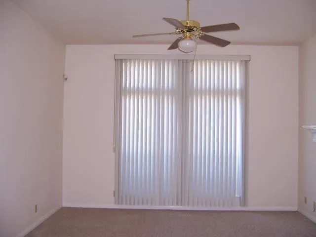 a view of a livingroom with a ceiling fan and window