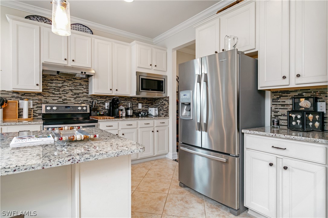 10922 Dennington Road Fort Myers, FL 33913 - Photo 12 of 35 a kitchen with stainless steel appliances granite countertop a refrigerator a stove a sink and white cabinets