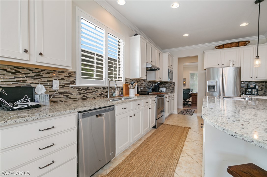 10922 Dennington Road Fort Myers, FL 33913 - Photo 15 of 35 a kitchen with stainless steel appliances granite countertop a stove a sink and a refrigerator