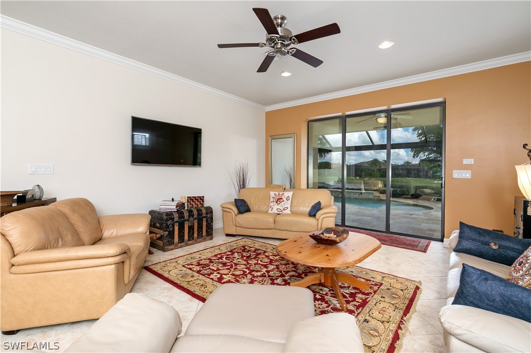 10922 Dennington Road Fort Myers, FL 33913 - Photo 16 of 35 a living room with furniture a flat screen tv and a floor to ceiling window