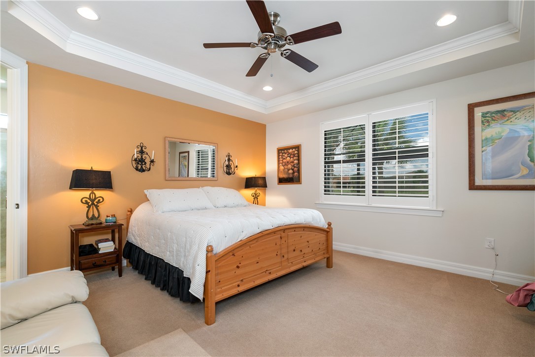 10922 Dennington Road Fort Myers, FL 33913 - Photo 20 of 35 a spacious bedroom with a bed a window and a chandelier