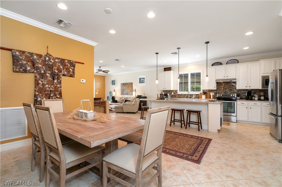 10922 Dennington Road Fort Myers, FL 33913 - Photo 27 of 35 a kitchen with a dining table chairs and refrigerator