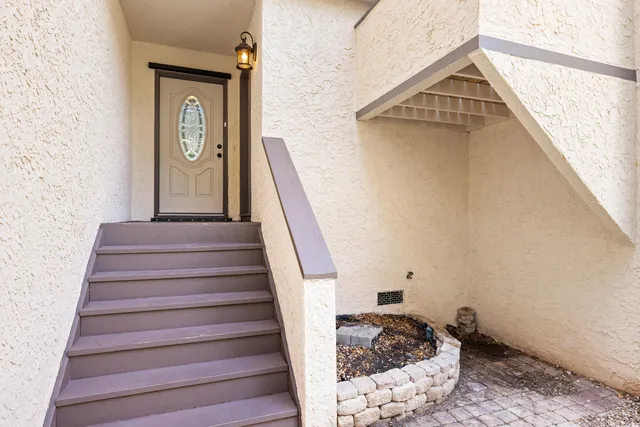 a view of empty room with wooden floor and kitchen
