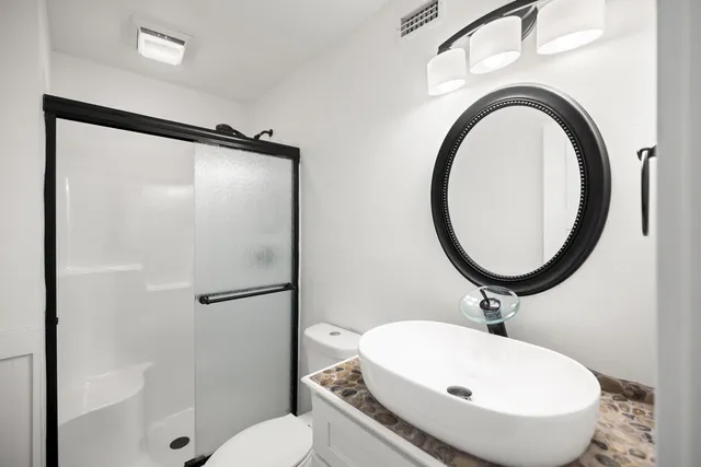 a kitchen with granite countertop white cabinets and stainless steel appliances