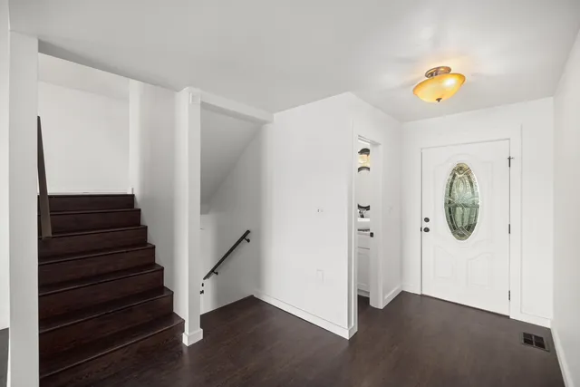 a kitchen with stainless steel appliances granite countertop a refrigerator a stove a sink and white cabinets