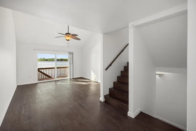 a kitchen with stainless steel appliances a refrigerator a sink dishwasher a stove and white cabinets with wooden floor