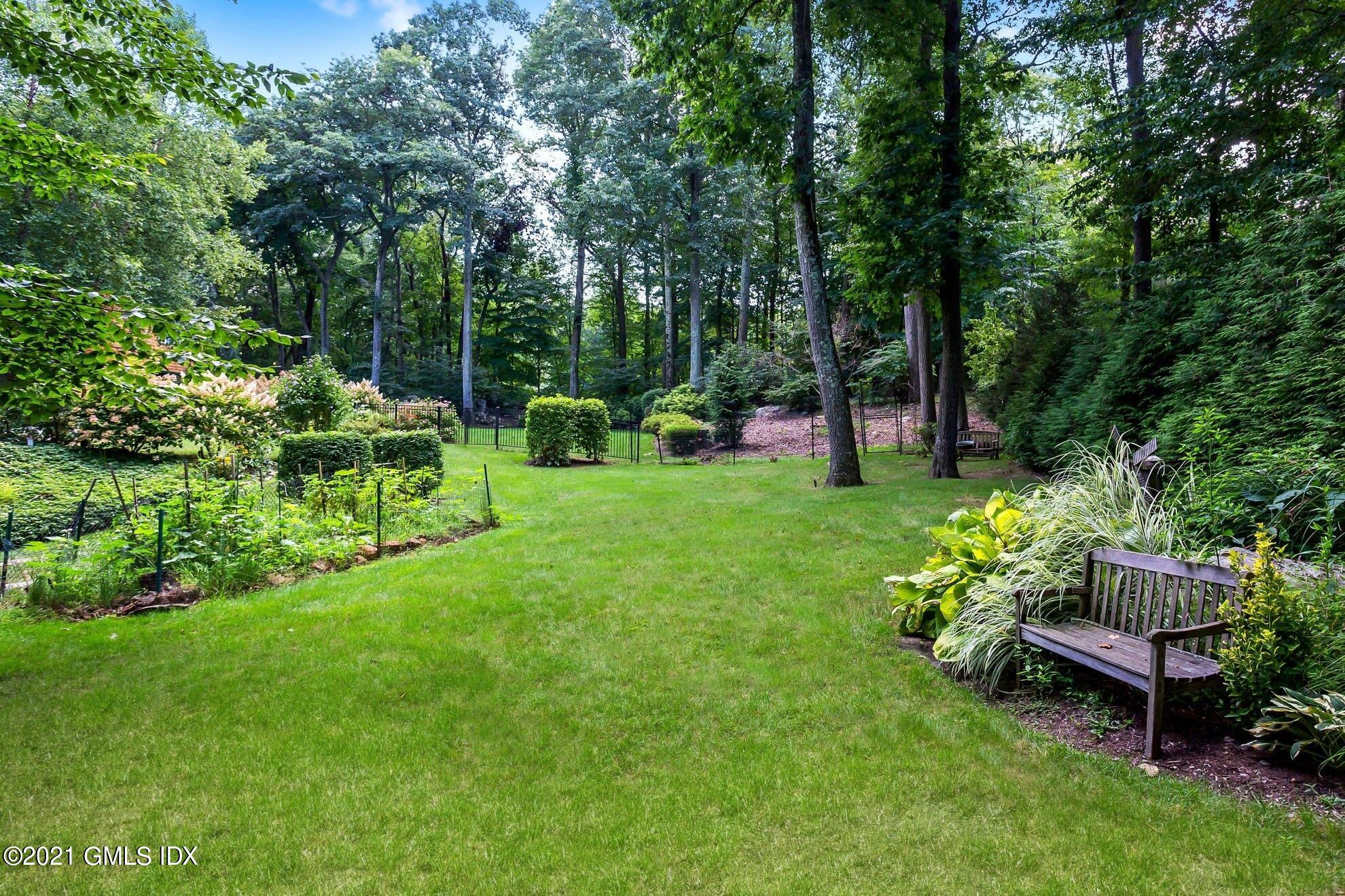 7 Chateau Ridge Road Greenwich, CT 06831 - Photo 23 of 36 a garden with a bench and some trees