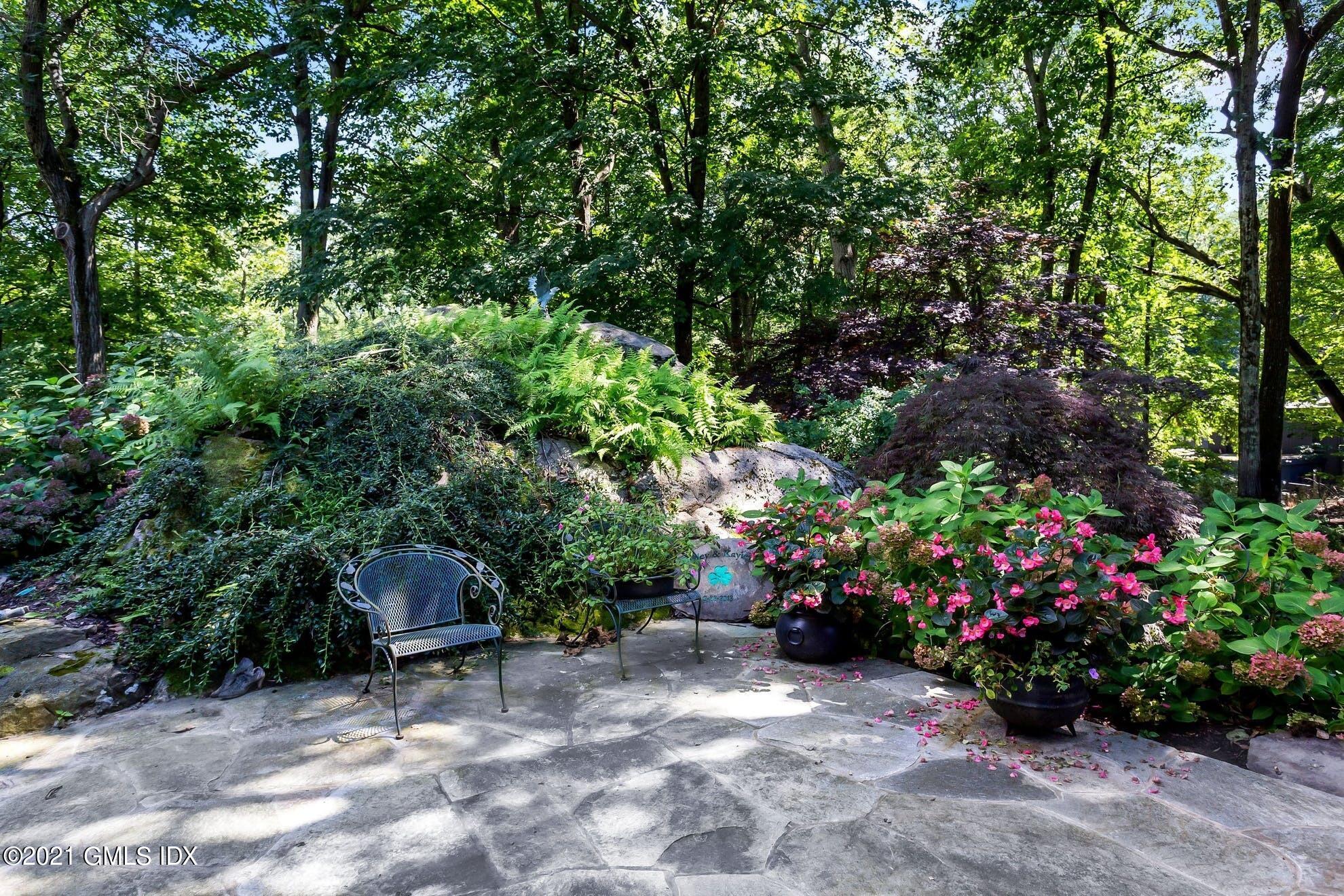 7 Chateau Ridge Road Greenwich, CT 06831 - Photo 27 of 36 a backyard of a house with lots of green space and garden view