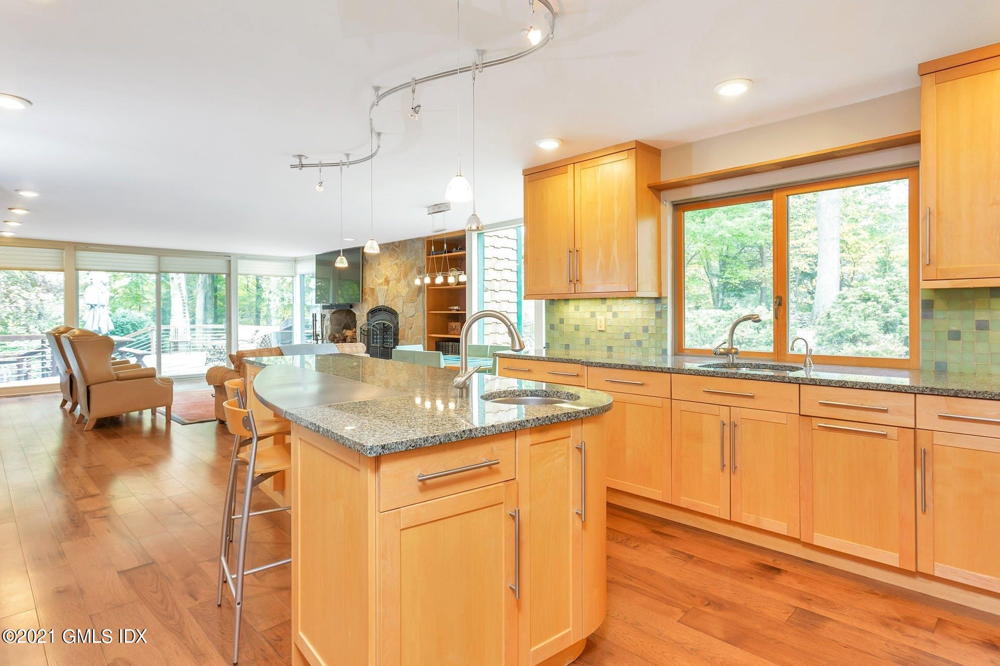 7 Chateau Ridge Road Greenwich, CT 06831 - Photo 7 of 36 a kitchen with granite countertop a stove a sink and a dining table with wooden floor